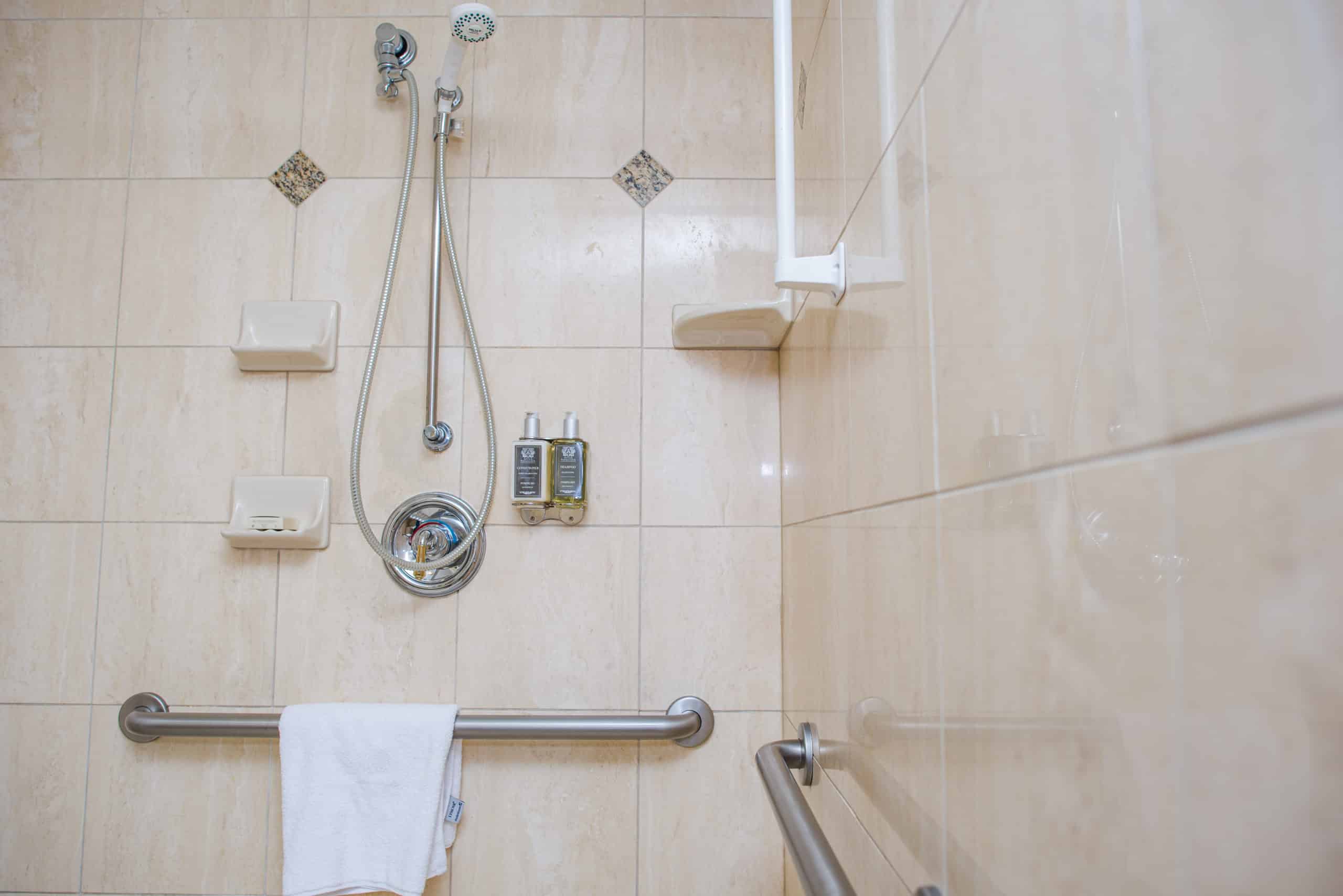 Spacious shower with grab bars and adjustable shower head at Mayflower Park Hotel in Seattle