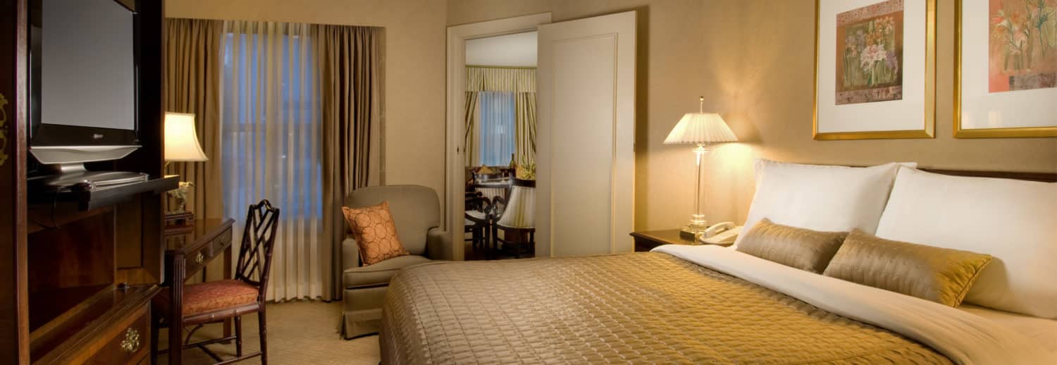 Executive suite bedroom featuring large king bed with a separate seating area at our hotel near the Space Needle.