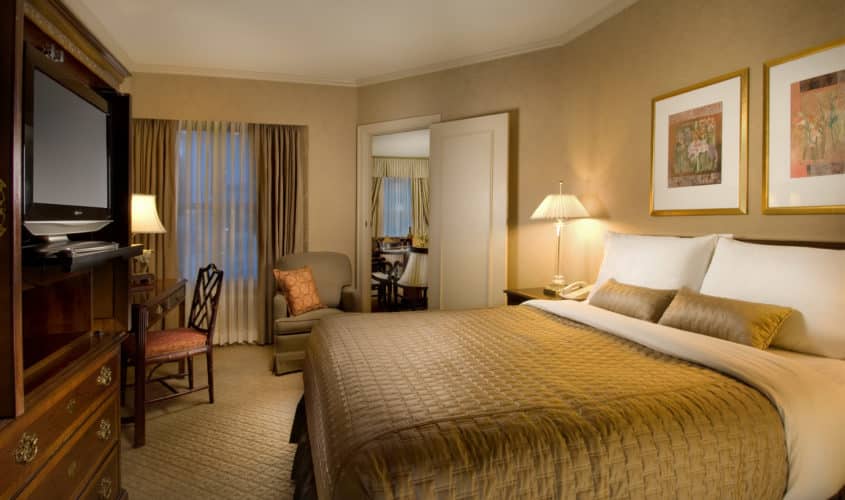 Executive suite bedroom featuring large king bed with a separate seating area at our hotel near the Space Needle.