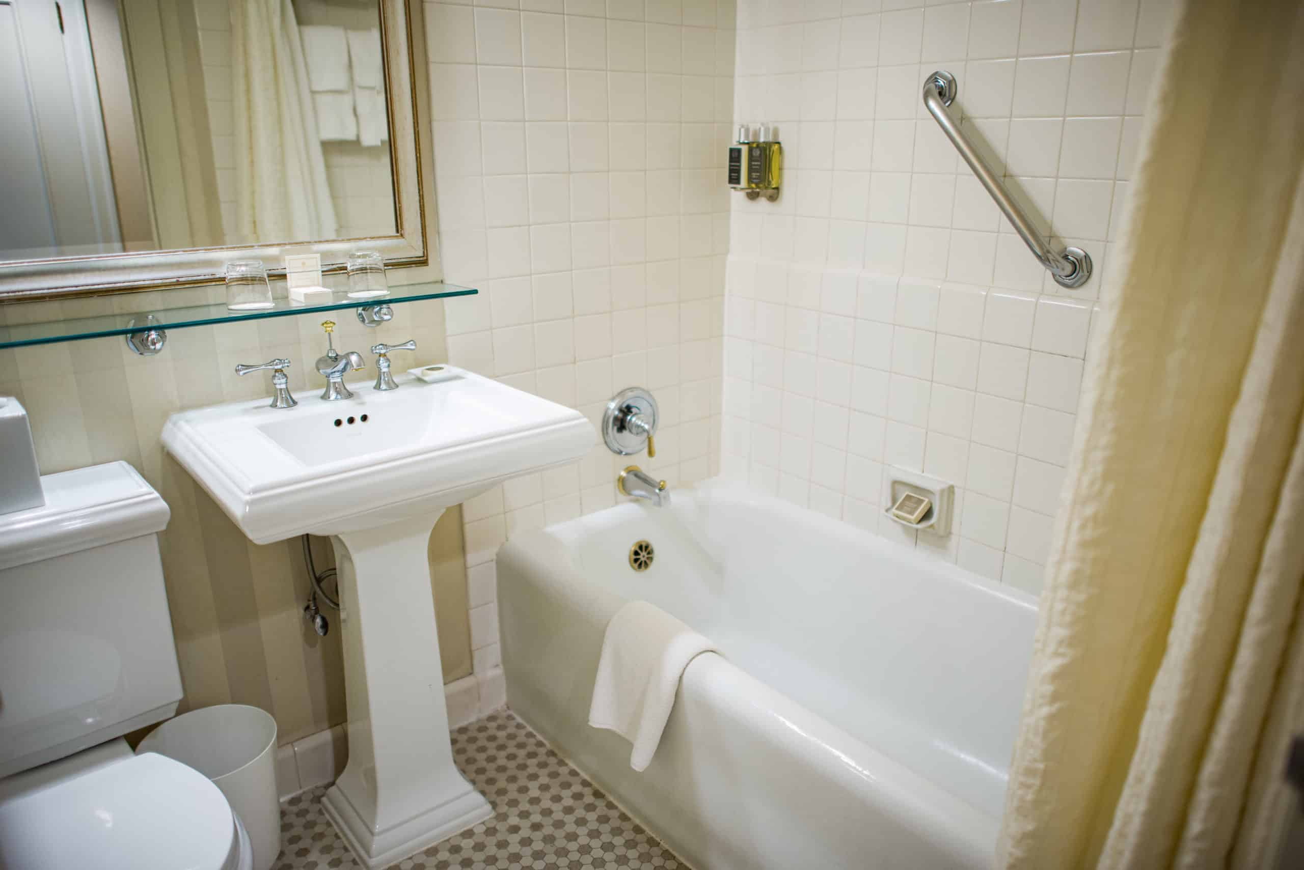 Seattle hotel guestroom featuring toilet, basin & tub with grab bar