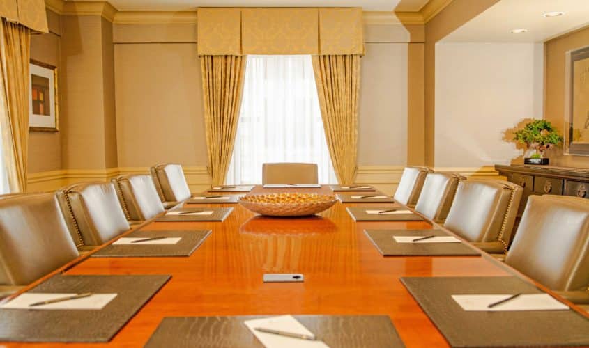 Intimate board meeting venue with large table and window for natural light at our Seattle hotel