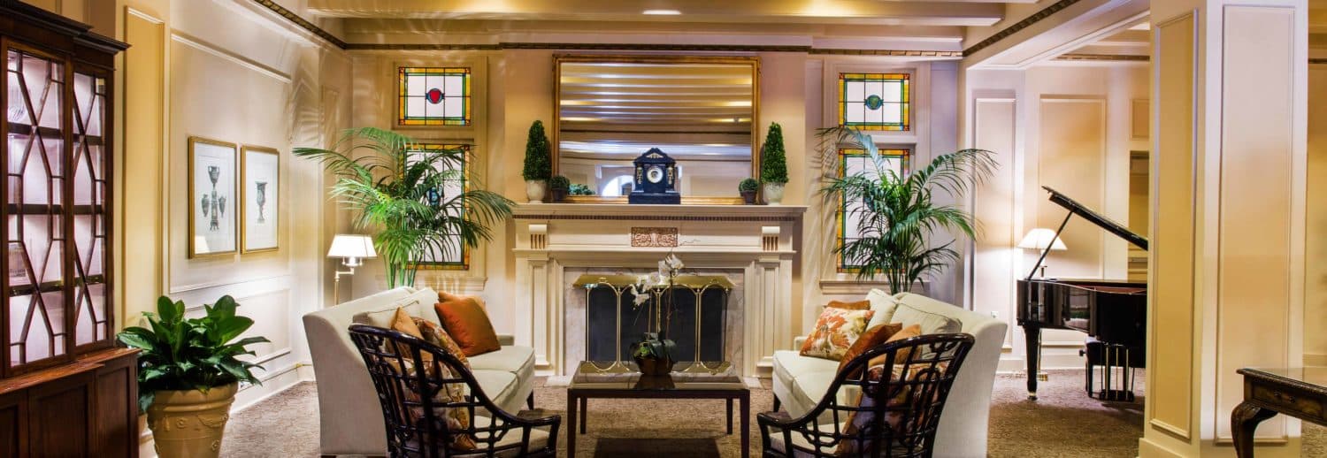 Lounge area with fireplace and baby grand piano in our historic Seattle hotel.