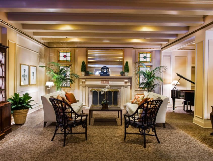 Lounge area with fireplace and baby grand piano in our historic Seattle hotel.