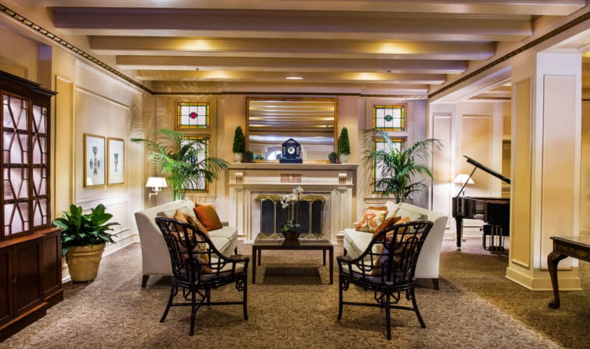 View of Seattle's hotel Fireside Room featuring two white sofas & chairs in front of the fireplace