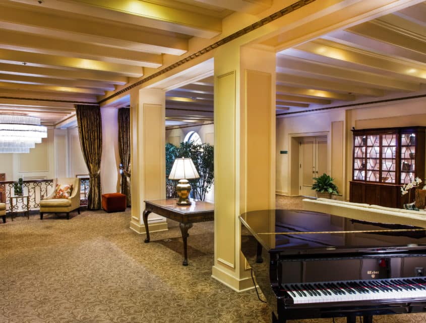 Fireside room set with a grand piano, chairs & open space for events at our historic Seattle hotel