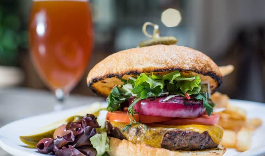 Savory cheeseburger with lettuce, onion, tomatoes and pickle with fries at our Seattle restaurant