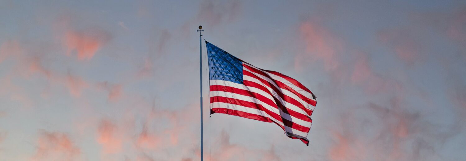 american flag in front of a sunset