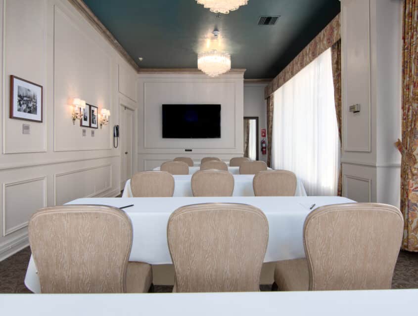 Four rows of tables with white tablecloth in the Rose Room, one of our Seattle event spaces.