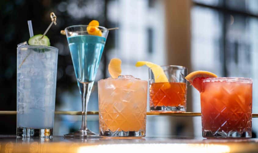 Various sized drinks of various colors with garnishes at our downtown Seattle dining establishment